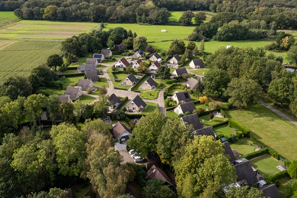 Drohnenaufnahme des Ferienparks Posterbos mit dem Ferienhaus inmitten der grünen Natur