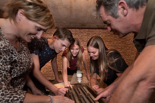 Een gezin maakt een puzzel in een escape room